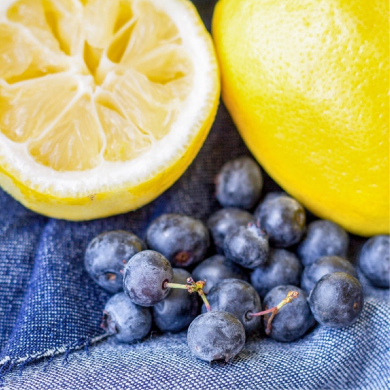 cut lemon with blue berries on cloth